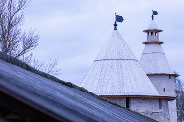 Stone tower or turret of ancient or antique kremlin or fortress with wood roof in the cloudy spring or autumn weather