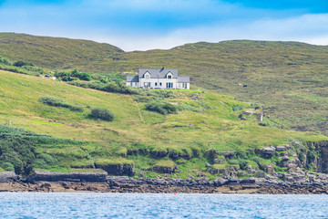 English Country House on a lush green hill surrounded by greener on the banks of the lake in Scotland © Revati