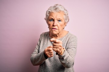Senior beautiful woman wearing casual t-shirt standing over isolated pink background Ready to fight...