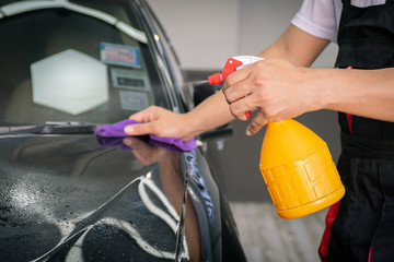 Car cleaning auto service : the man sprays water - car detailing concepts