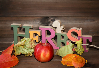 eine Dekoration für den Herbst mit Apfel und Blätter