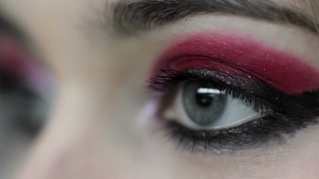 Vision correction. Laser eye surgery. Woman with red eyeshadow black liner makeup.
