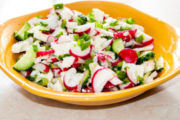 The process of preparing vegetable salad with feta cheese.
