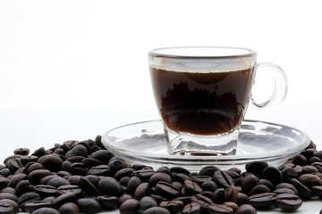 Small glass transparent coffee cup saucer full coffee beans