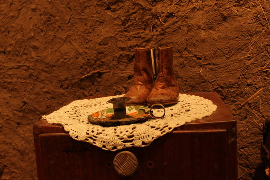 Zapatos antiguos y candelaria sobre velador