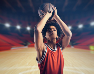 Young African American boy with basketball taking a free throw