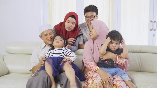 Muslim three generation family watches TV together