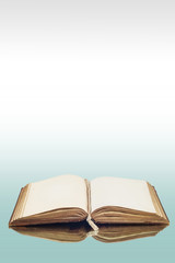 An old vintage book reflecting on a glass surface