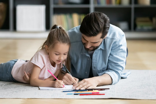 Young dad have fun drawing with little daughter