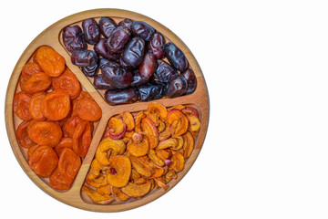Dried fruits in a wooden bowl on a white background