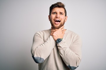 Young handsome blond man with beard and blue eyes wearing casual sweater shouting and suffocate...