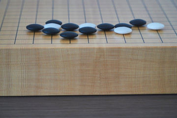 Closeup of some go stones with blurred edge of go board