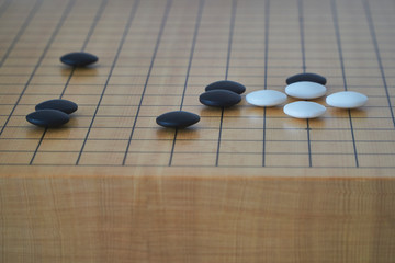 Closeup of some go stones with blurred edge of go board