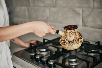 Fototapeta na wymiar girl brews coffee in turk