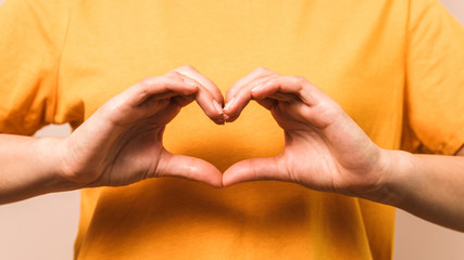closeup hands of woman in shape of heart. self-love and prosperity