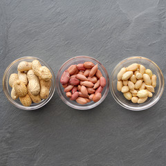 Top view of three bowls of peanuts, healthy snack