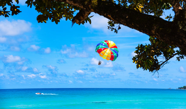 Parasailing above the ocean at tropical island.