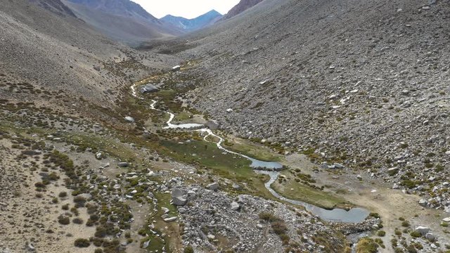 An aerial view inside Andes mountains at Limari Valley, south Atacama. An amazing wild scenery. Arid idyllic valleys with green farm fields feed in by the river at the bottom of the valley
