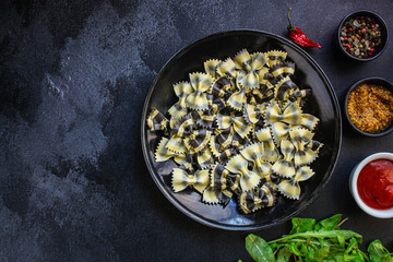 pasta farfalle cuttlefish ink (healthy eating, black multi-colored) menu concept. food background. top view. copy space