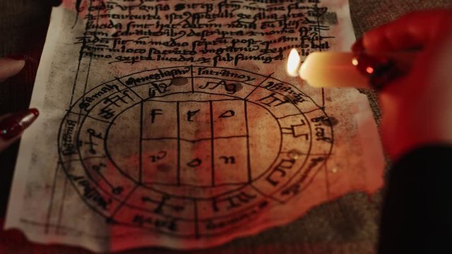 Cropped view of fortune teller dripping wax on pentagram during occult ritual