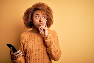Young African American afro woman with curly hair having conversation using smartphone serious face...