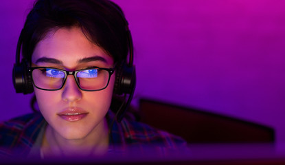 Concentrated Girl Playing Game Sitting At PC Indoor At Night