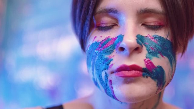 Transcendent dance. Meditation freedom. Woman with paint on face falling in trance with eyes closed.