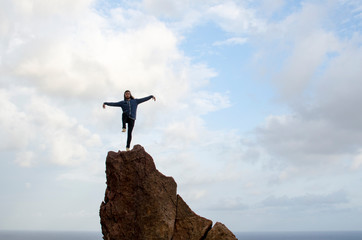 man on top of a high rock doing poses