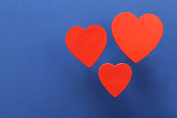 Fototapeta na wymiar Red hearts on blue background.