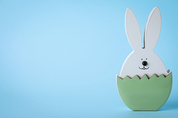 Easter bunny figure on light blue background. Space for text