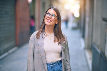Fototapeta premium Young beautiful woman smiling happy and confident. Standing with smile on face at the town street