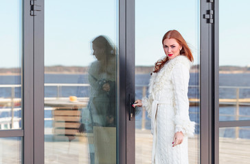 Beautiful woman in white knitted coat.