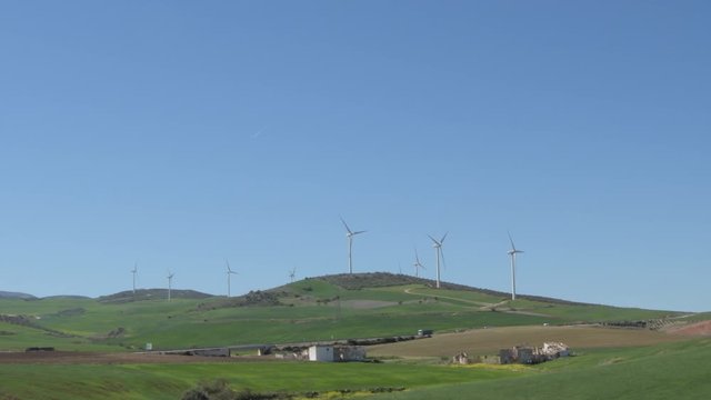 Landscape of wind turbines in a hill moving blades with blue sky