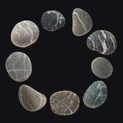 Round frame from a set of different color stones. Stock photo element Scandinavian trend design on dark background.