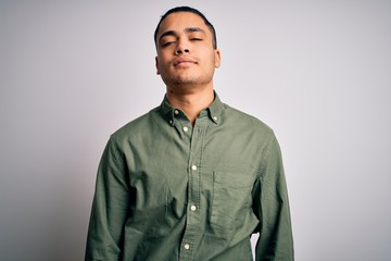 Young brazilian man wearing casual shirt standing over isolated white background Relaxed with serious expression on face. Simple and natural looking at the camera.