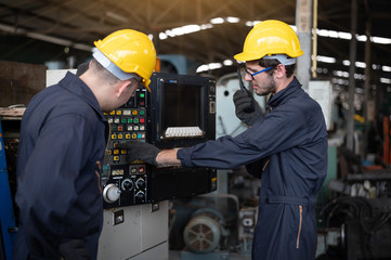 Two technicians are surveying the machine and recording the inspection details and status reports...