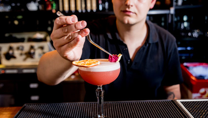 Bartender is making cocktail at bar counter. Fresh cocktails. Barman at work. 
