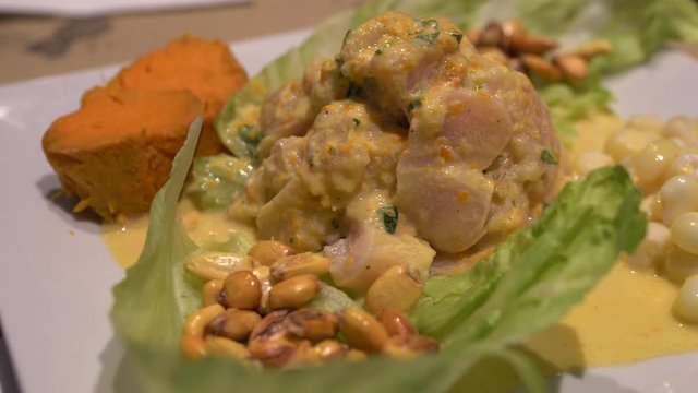 Un primer plano de ceviche, un plato fresco y &aacute;cido hecho con pescado marinado en lim&oacute;n o lima, mezclado con cebolla, cilantro, y chiles. Ideal para destacar la cocina peruana y su sabor vibrante