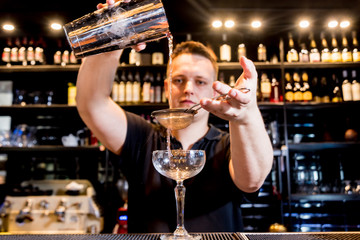 Bartender is making cocktail at bar counter. Fresh cocktails. Barman at work. 
