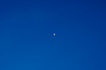 The Half Moon on daylight on blue sky nature background.  long-distance photo