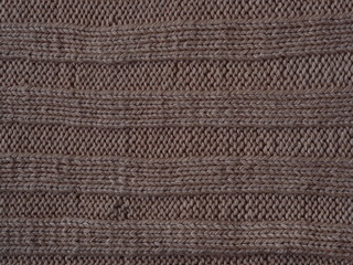 Brown knitted textured background, knit with the front and back loops. Hand knitting.