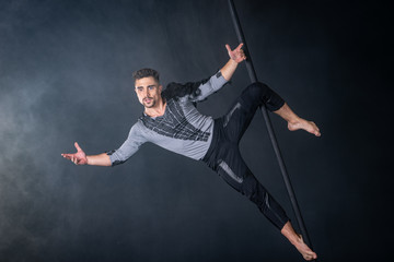 Performance concept. Man hanging on chinese pole. Athlete performing flying pole