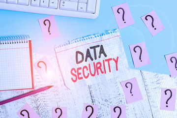 Conceptual hand writing showing Data Security. Concept meaning the process of protecting data from unauthorized access Writing tools and scribbled paper on top of the wooden table