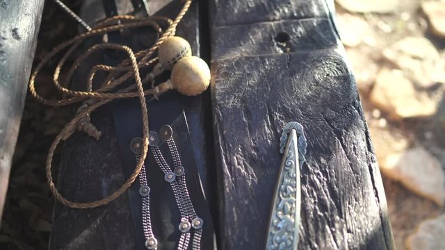 Un banco de madera antiguo t&iacute;pico argentino exhibe un cuchillo y boleadoras, representando la tradici&oacute;n y la cultura gaucha.