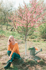 Girl watering plants in a garden. Gardener girl gardening on spring garden.