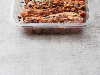 Soy sous and herbs fresh uncooked marinated pork belly slices in a plastic package on a simple table cloth, copy space.