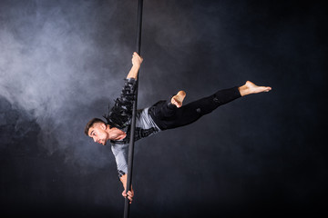 Performance concept. Man hanging on chinese pole. Athlete performing flying pole