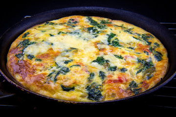 Frittata made of eggs, bacon, cheese and spinach