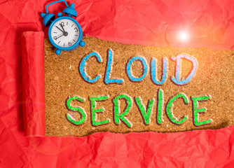 Text sign showing Cloud Service. Business photo showcasing refers to variety of resources provided over the internet Alarm clock and torn cardboard placed above a wooden classic table backdrop