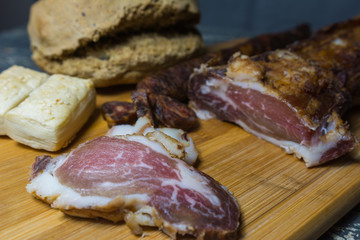 Homemade dried meat and sausage cut into pieces and homemade bread.
